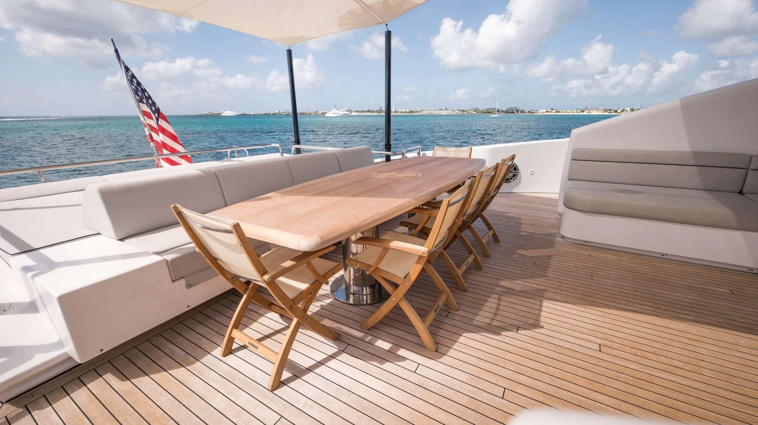 a wooden table and chairs on a deck overlooking the ocean aboard BLUE DEVIL Yacht for Sale