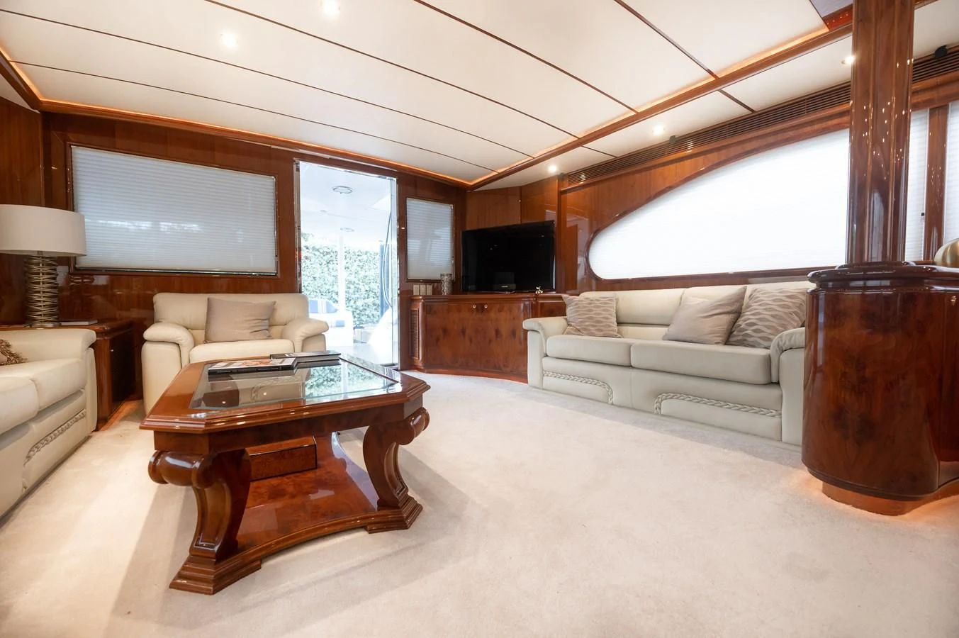 a living room with a large wood table and a large wood cabinet aboard DOLCE VITA Yacht for Sale