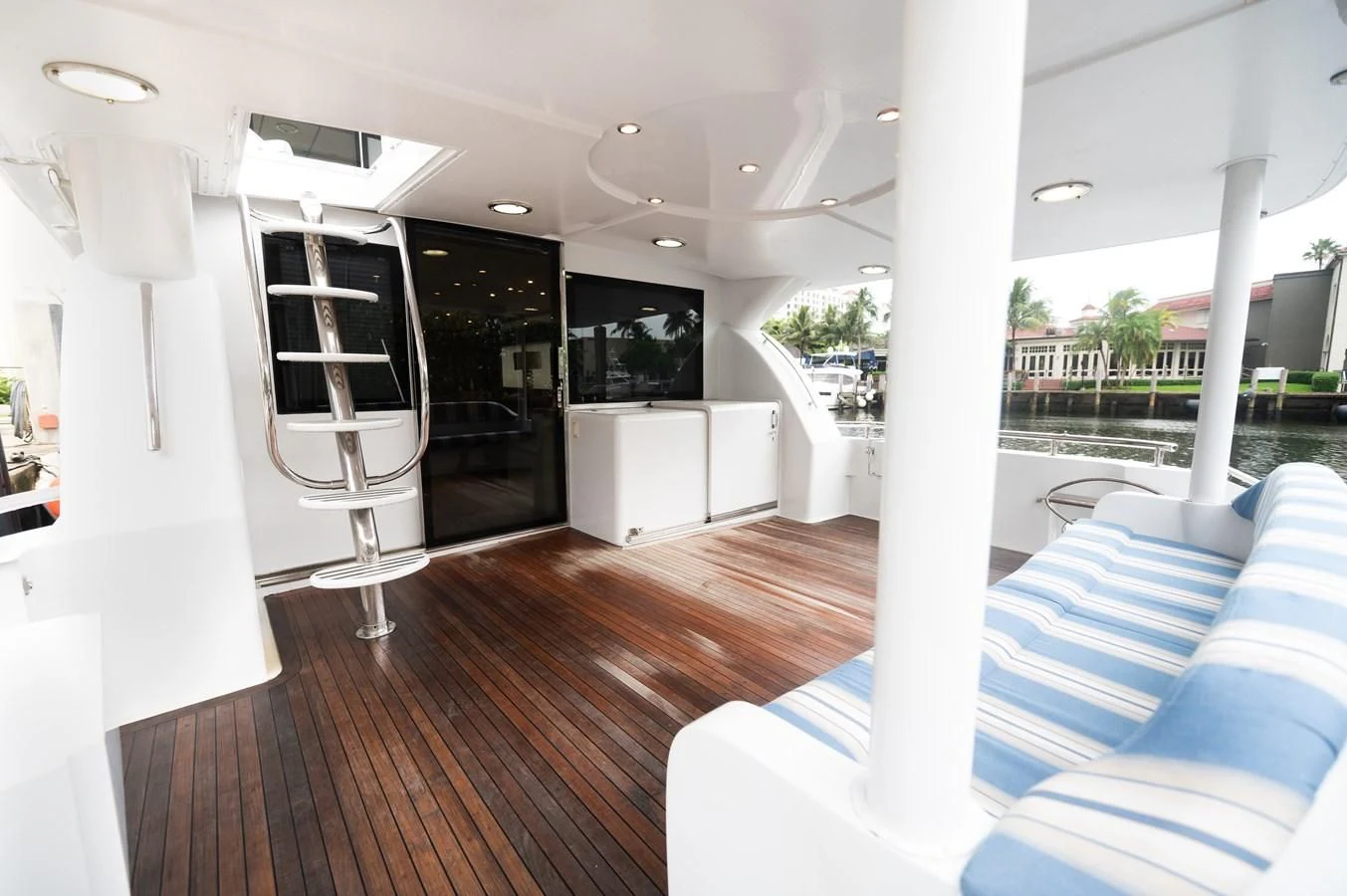 a room with a wood floor and a large window with a view of the water and the pool aboard DOLCE VITA Yacht for Sale