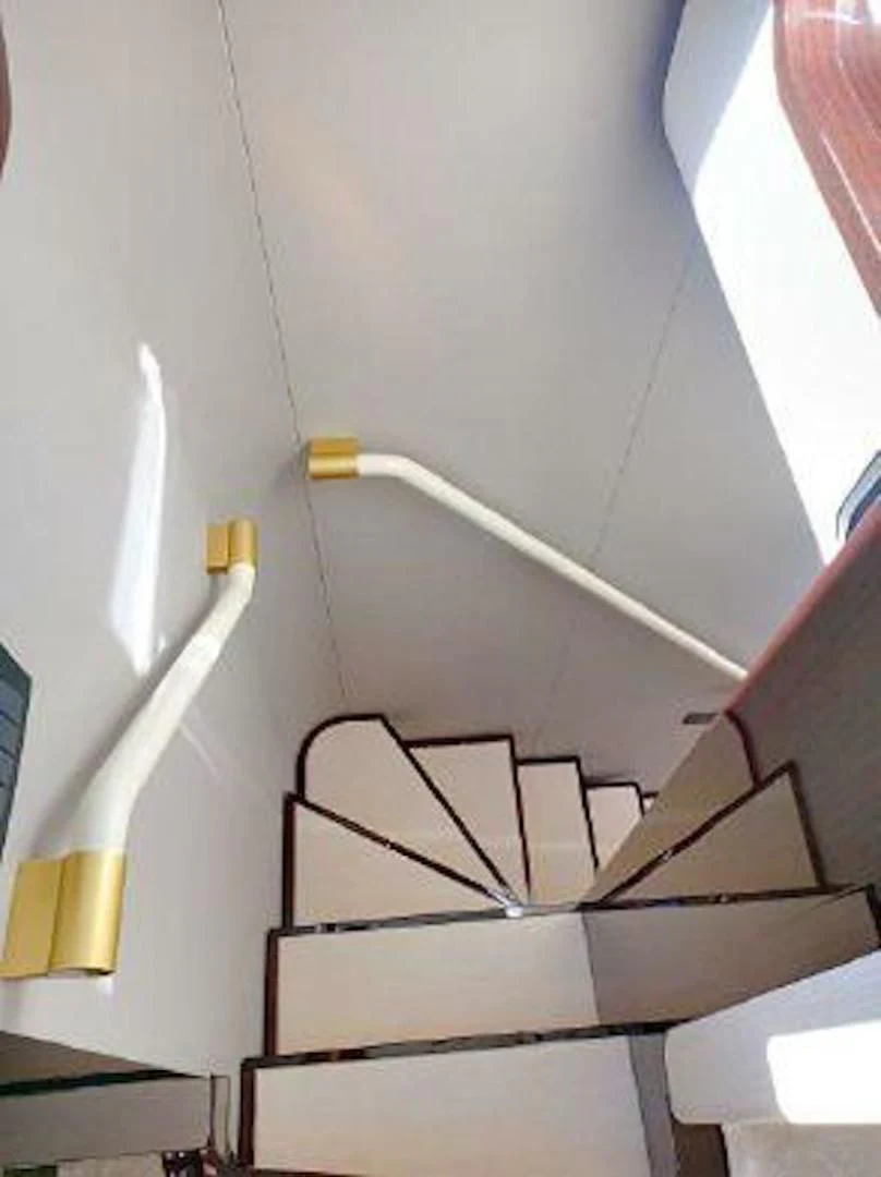 a white staircase with a metal railing aboard NOMAD Yacht for Sale