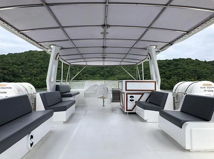 a room with a couch and a table and chairs aboard BLUE DOLPHIN Yacht for Sale