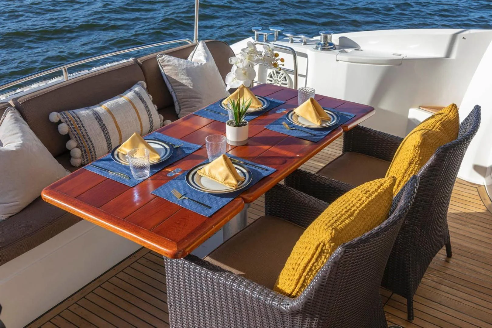 a table with a plate of food and a chair on it aboard UNFORGETTABLE Yacht for Sale