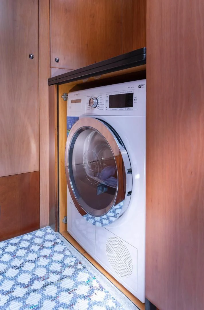 a washing machine in a wooden room aboard UNFORGETTABLE Yacht for Sale