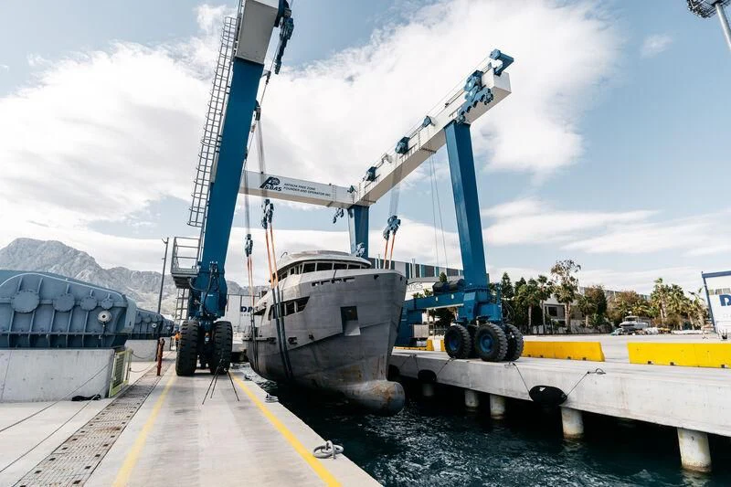 a large crane lifting a container aboard BERING 80/01 Yacht for Sale
