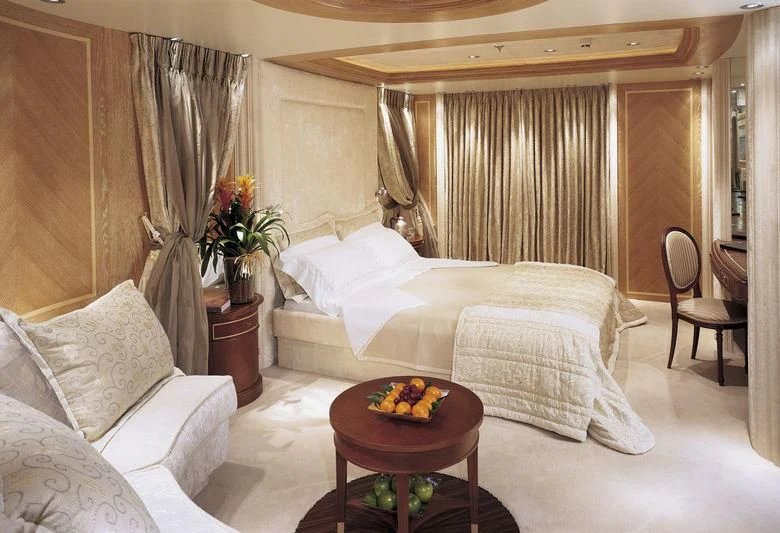 a bed and a table in a room aboard QUEEN MIRI Yacht for Sale