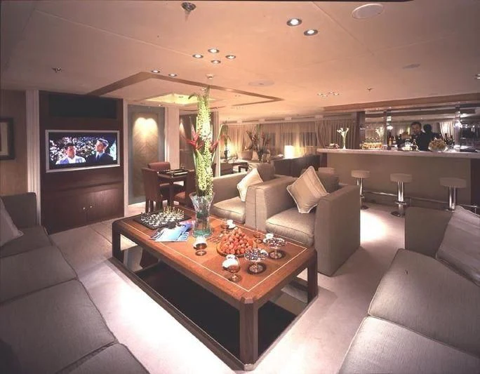 a living room with a table and couches aboard QUEEN MIRI Yacht for Sale