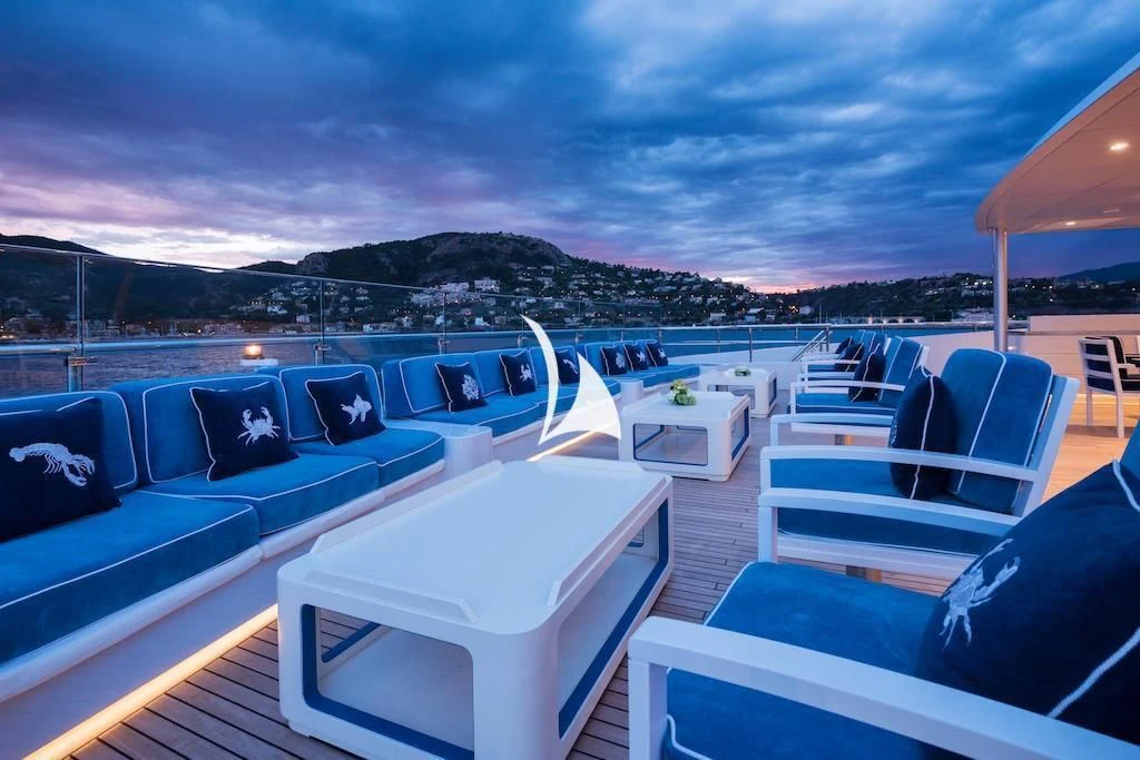 a deck with a view of the ocean and mountains aboard QUEEN MIRI Yacht for Sale