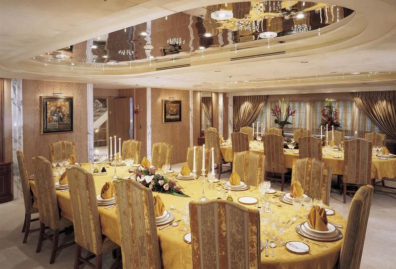 a large room with tables and chairs aboard QUEEN MIRI Yacht for Sale