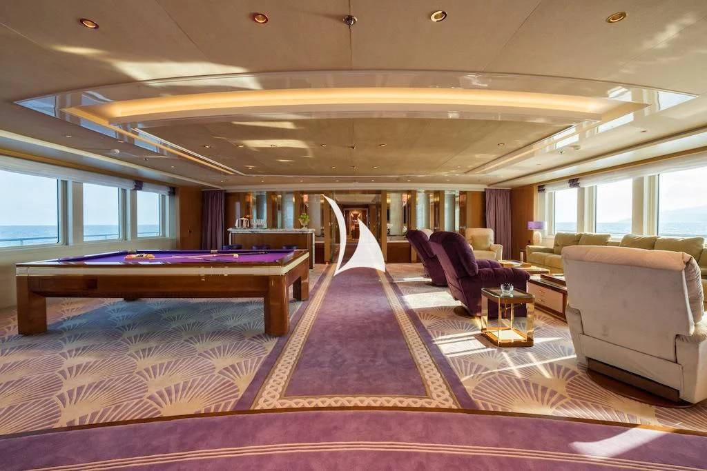 a large living room with a pool table and a couch aboard QUEEN MIRI Yacht for Sale