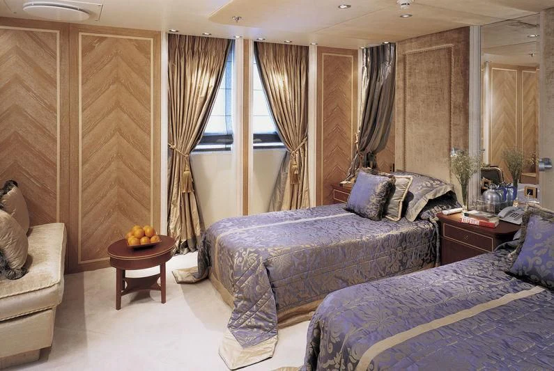 a bedroom with a bed and a table aboard QUEEN MIRI Yacht for Sale