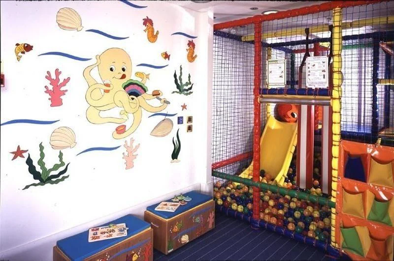a colorful playroom with a yellow and blue wall aboard QUEEN MIRI Yacht for Sale
