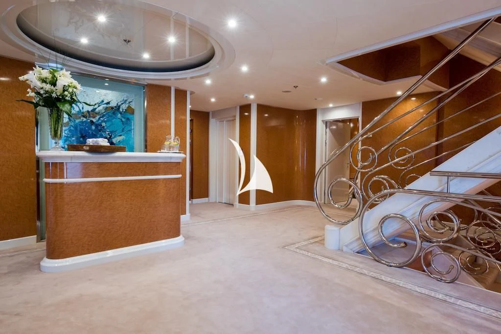 a large room with a staircase and flowers aboard QUEEN MIRI Yacht for Sale
