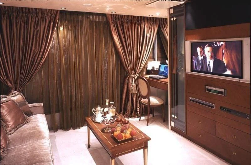 a living room with a tv and fruit on a table aboard QUEEN MIRI Yacht for Sale