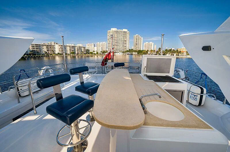 a deck with chairs and a table on it aboard BEYOND Yacht for Sale