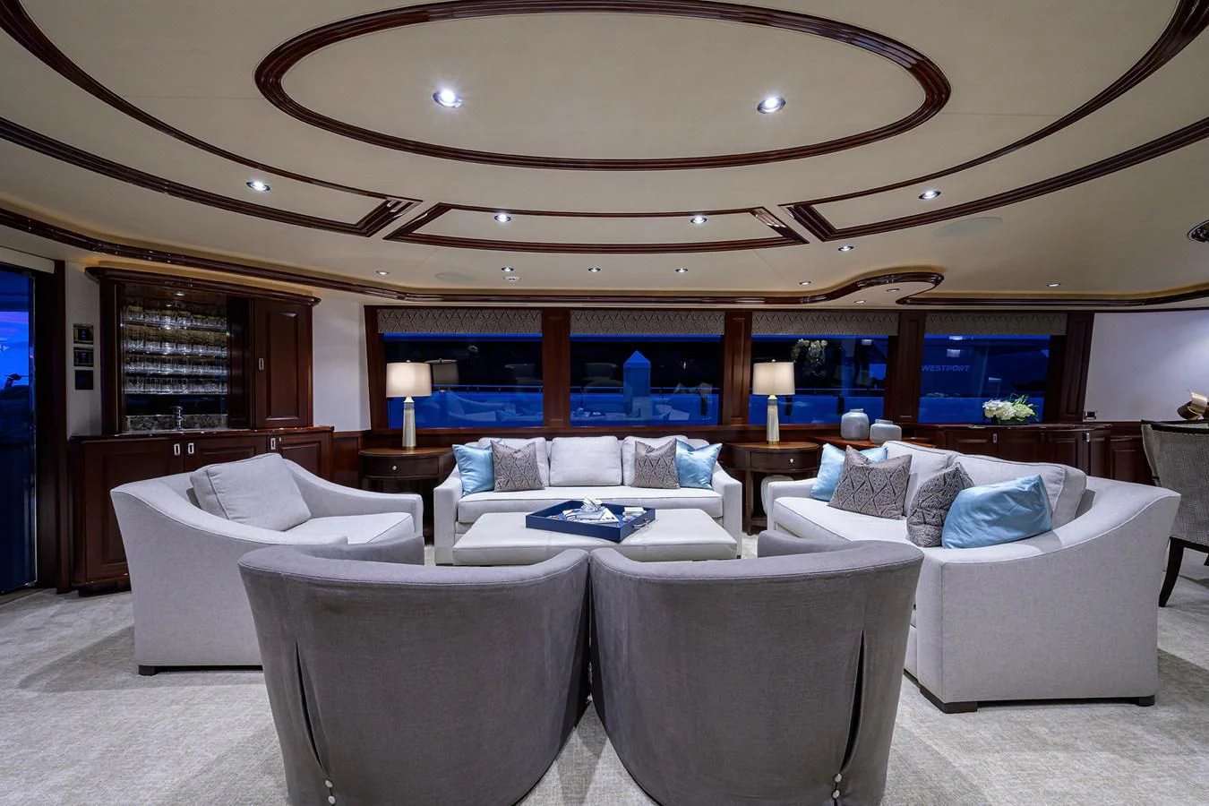 a large living room with a large mirror above the couch aboard DETERMINATION Yacht for Sale