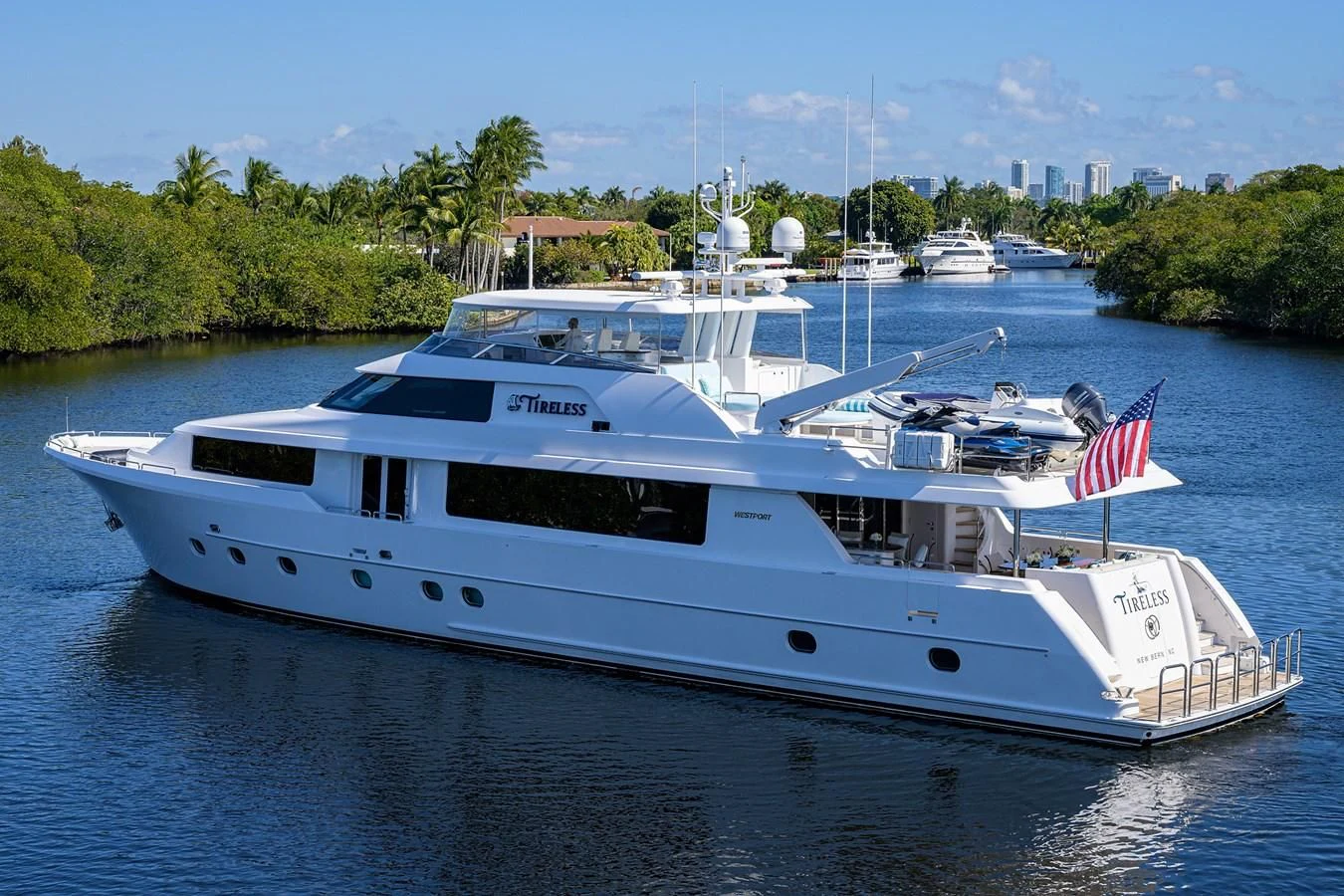 a large white boat with a flag on it aboard DETERMINATION Yacht for Sale