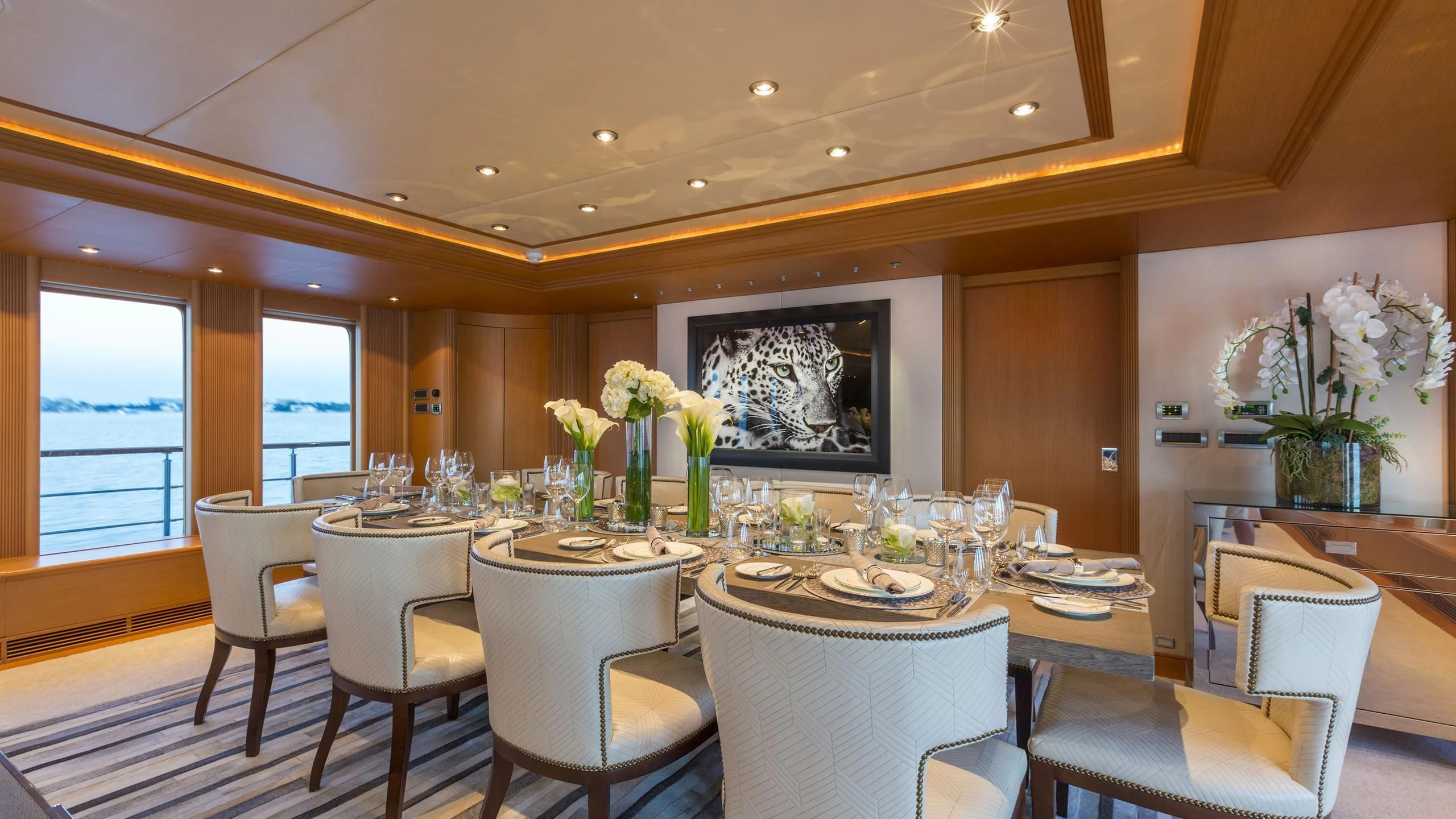 a dining room with white chairs and flowers aboard DEDE Yacht for Sale
