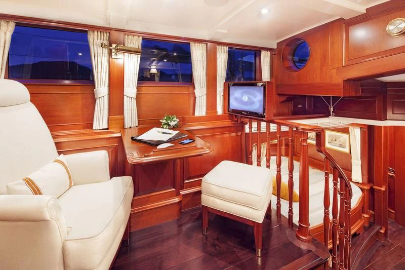 a room with a table chairs and a tv aboard KAMAXITHA Yacht for Sale