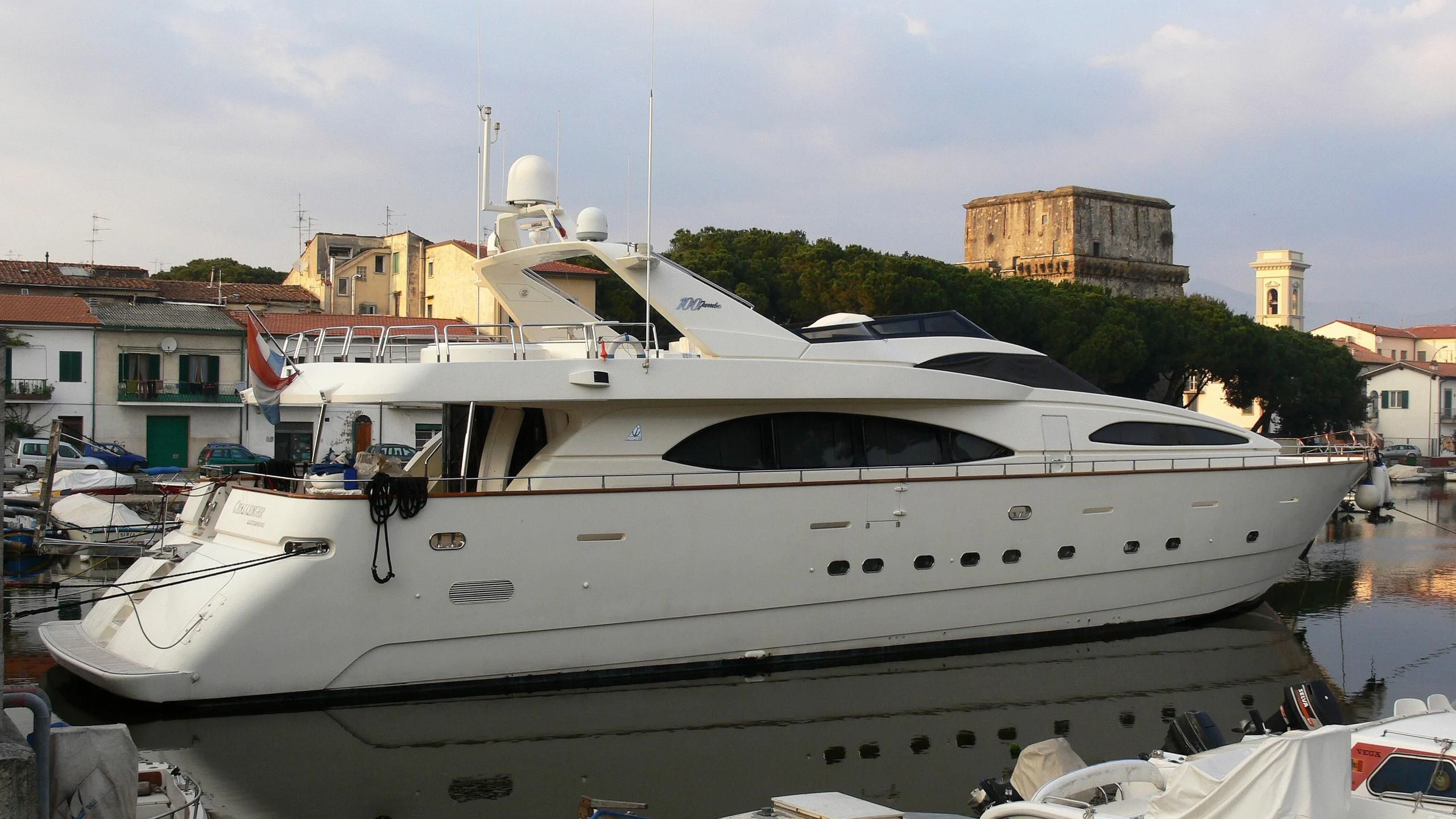 a white yacht in a harbor aboard SHAMBHALA Yacht for Sale