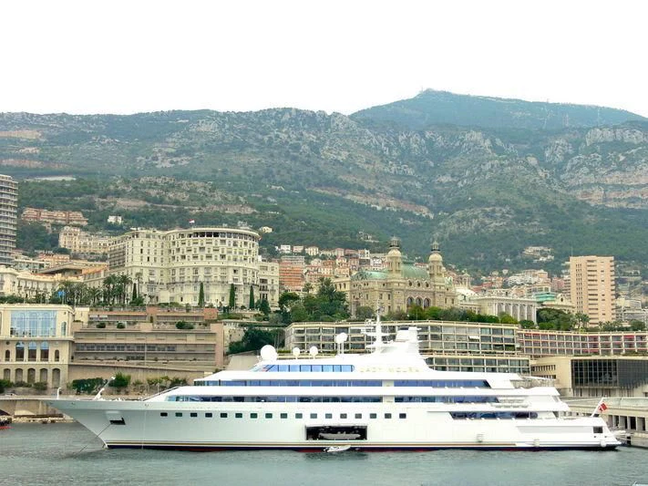 a large white yacht in a harbor aboard LADY MOURA Yacht for Sale