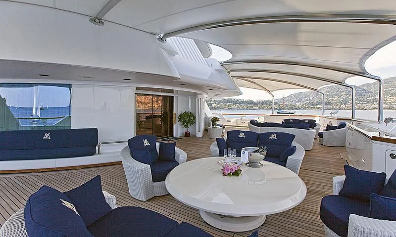 a large room with a table and chairs aboard LADY MOURA Yacht for Sale