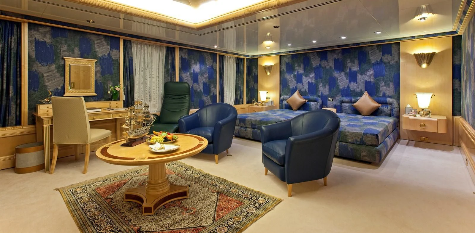 a living room with blue couches aboard LADY MOURA Yacht for Sale