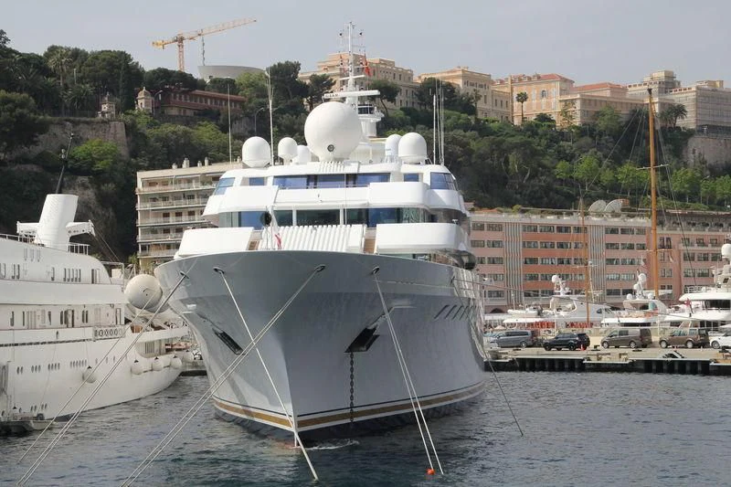 a large white boat in a harbor aboard LADY MOURA Yacht for Sale
