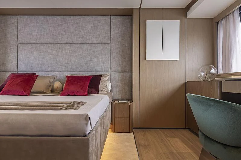 a bed with red pillows aboard EPIC Yacht for Sale
