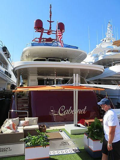 a man standing next to a boat aboard CABERNET Yacht for Sale