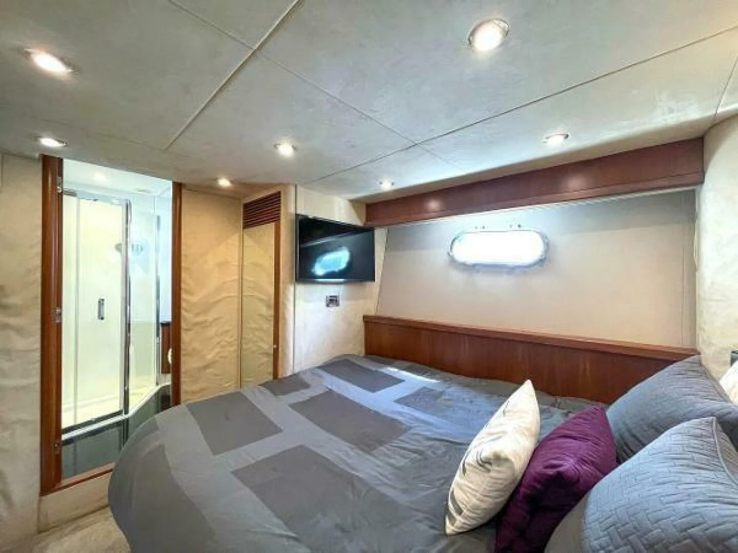 a bed with a television on the wall aboard TWINS Yacht for Sale