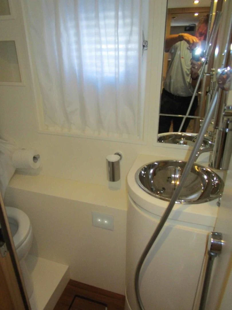 a person taking a picture of a bathroom sink aboard REGENCY Yacht for Sale