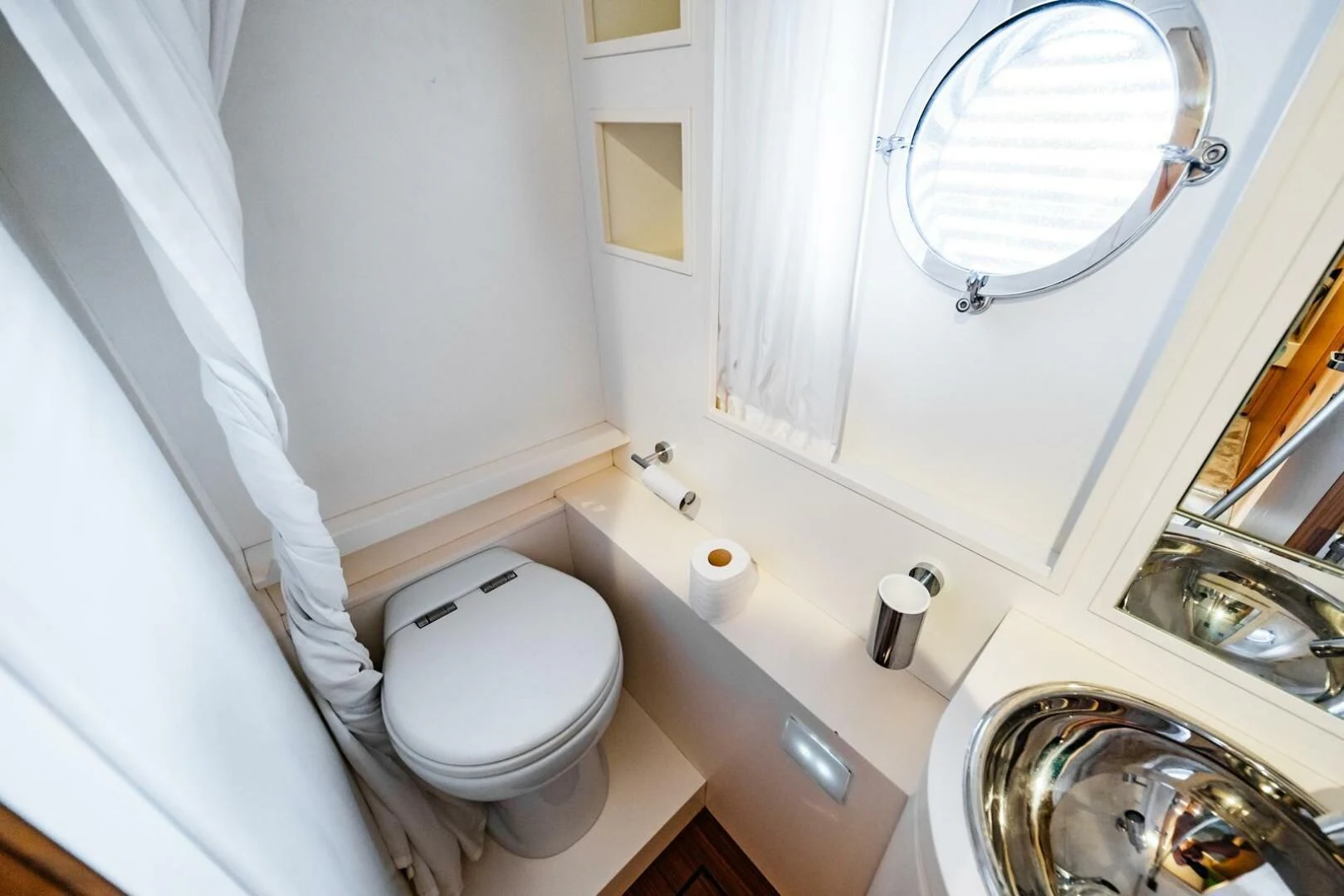 a toilet with a mirror above it aboard REGENCY Yacht for Sale