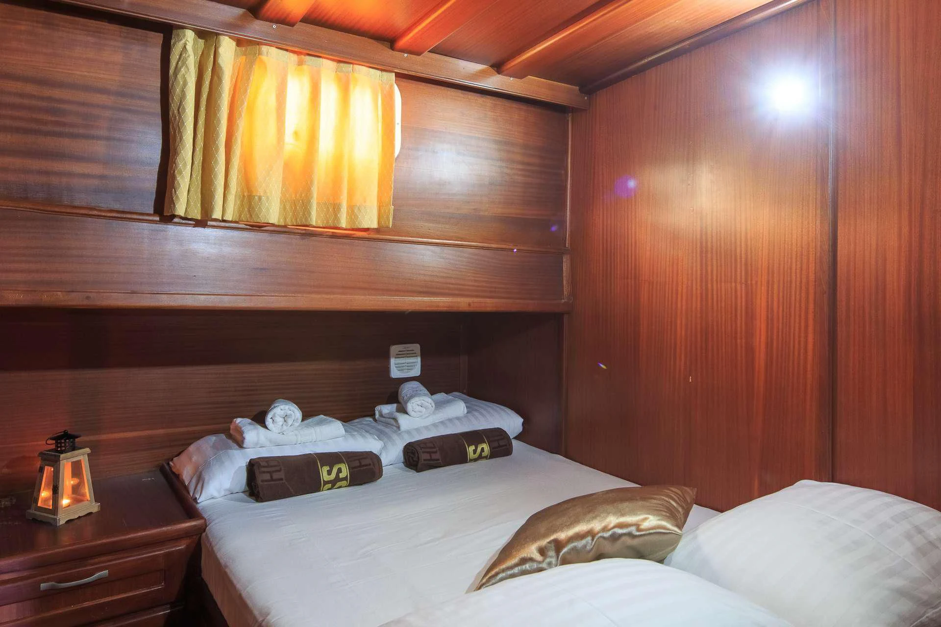a bed with a white sheet and a wooden wall aboard ALLURE E Yacht for Sale
