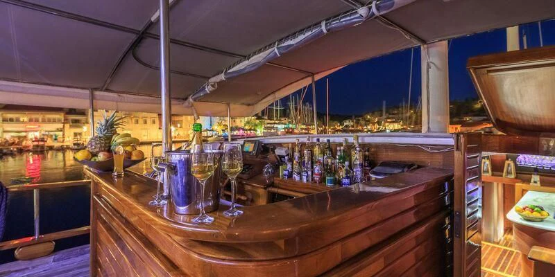 a bar with a bar and a table with glasses of wine aboard ALLURE E Yacht for Sale