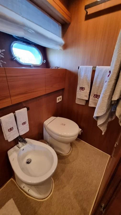 a bathroom with a toilet and a sink aboard BRIVIDO Yacht for Sale