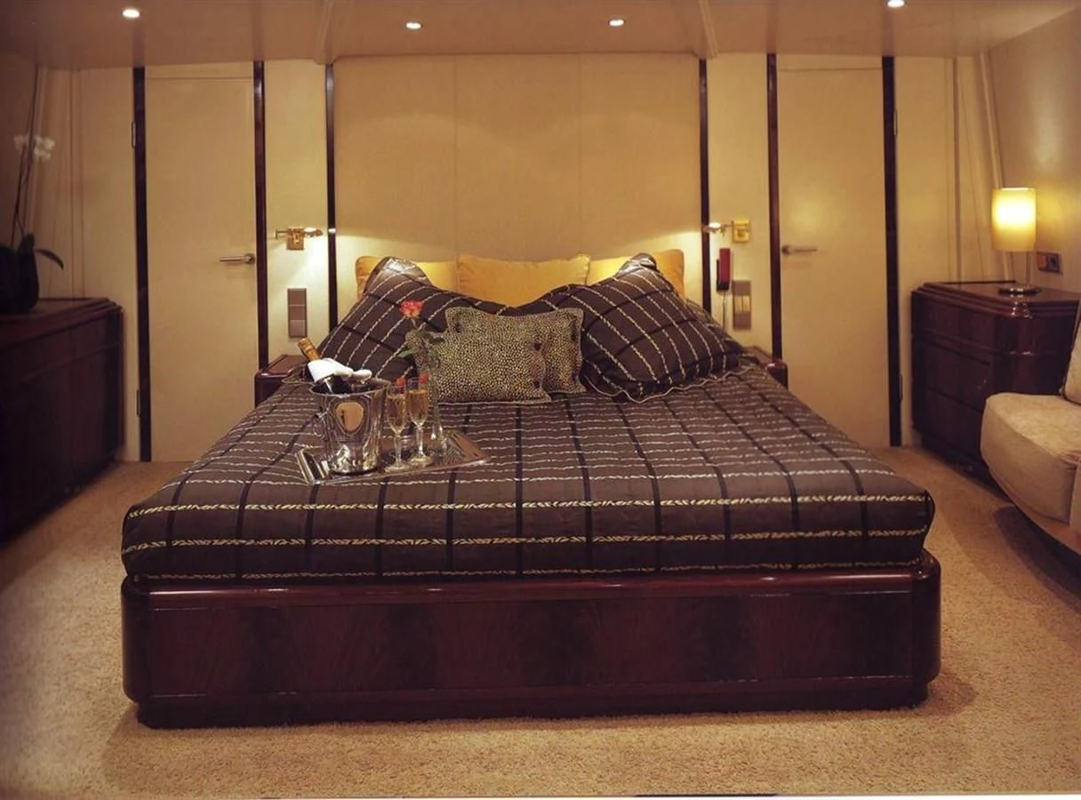 a bed with a black comforter aboard COSTA MAGNA Yacht for Sale