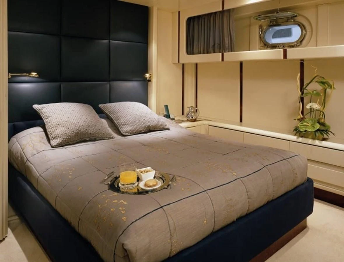 a bed with a blue bed spread aboard COSTA MAGNA Yacht for Sale