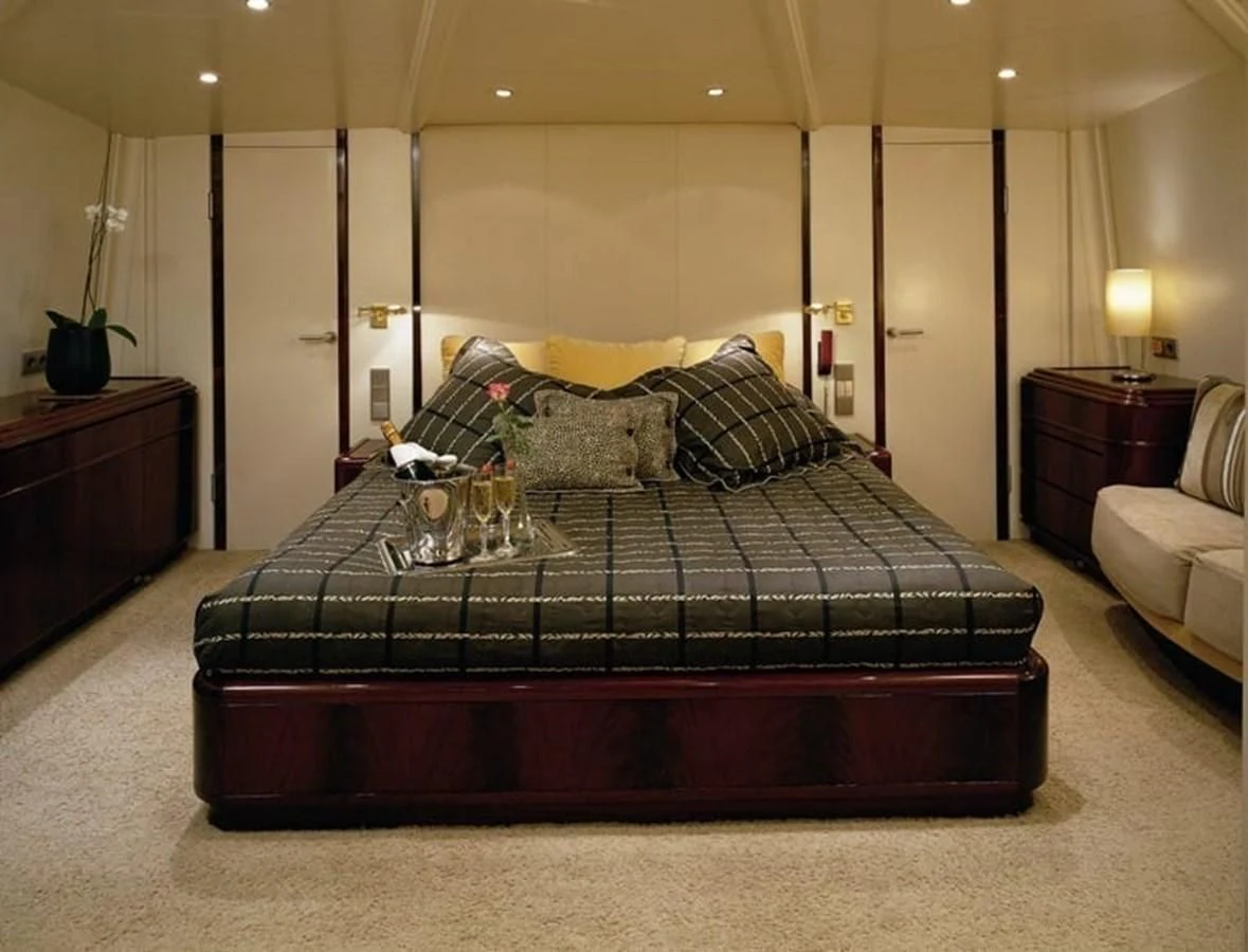 a bed with a black comforter aboard COSTA MAGNA Yacht for Sale