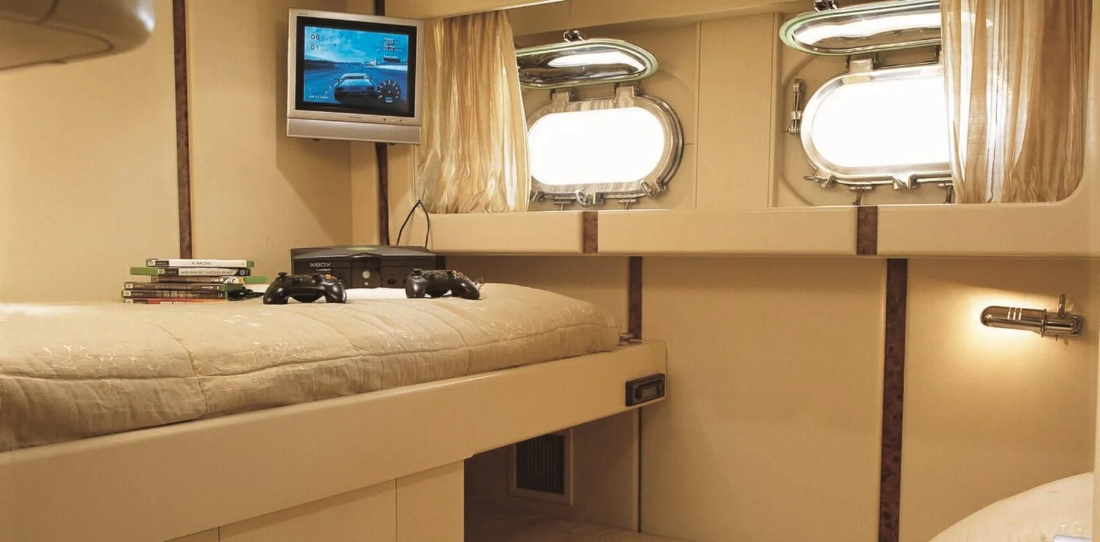 a bed with a television on the wall aboard COSTA MAGNA Yacht for Sale