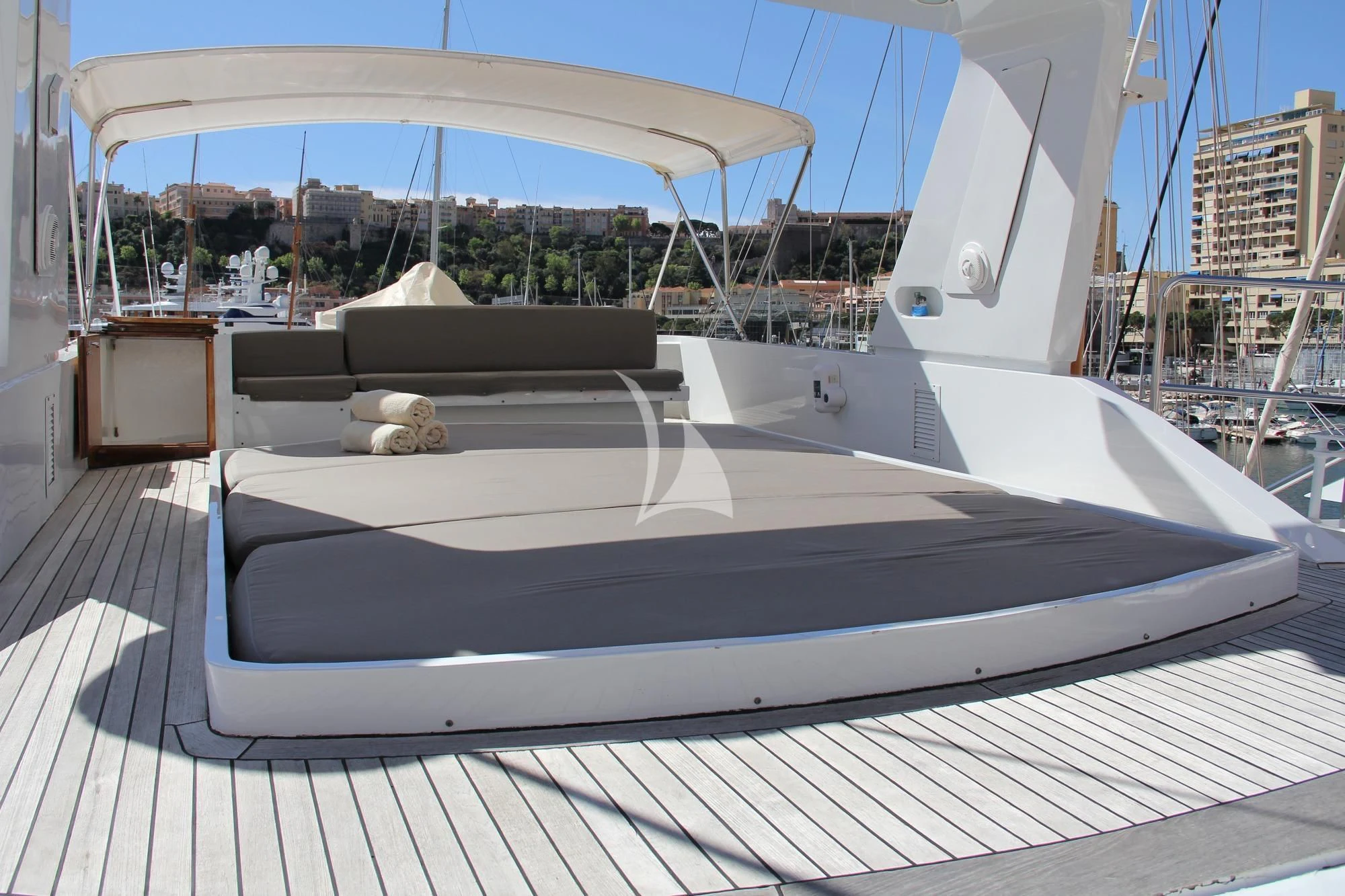 a large white lounge chair on a deck with a large white umbrella aboard COSTA MAGNA Yacht for Sale