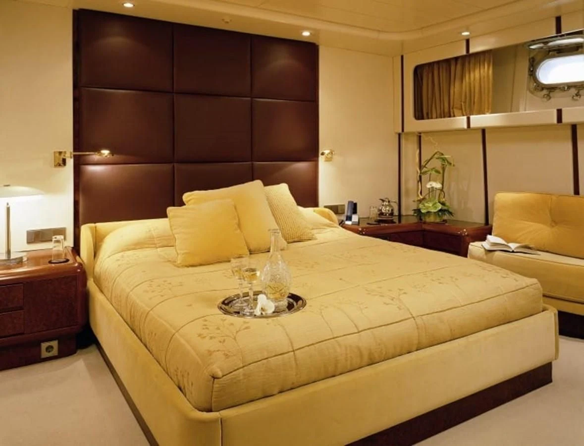 a bed with a white sheet and pillows aboard COSTA MAGNA Yacht for Sale