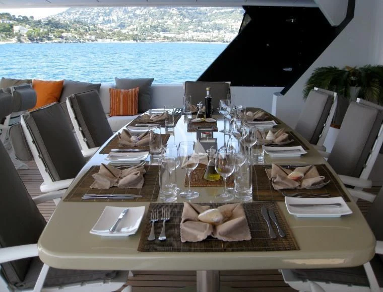 a table with plates and glasses aboard COSTA MAGNA Yacht for Sale