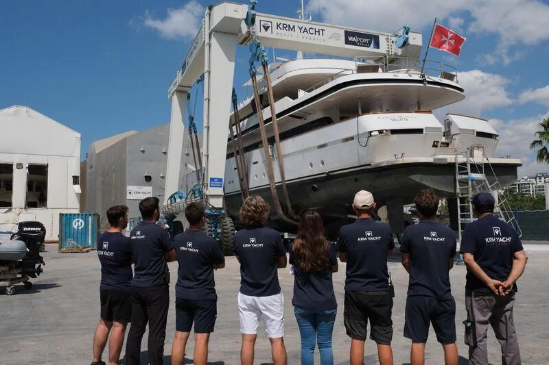a group of people standing next to a boat aboard COSTA MAGNA Yacht for Sale