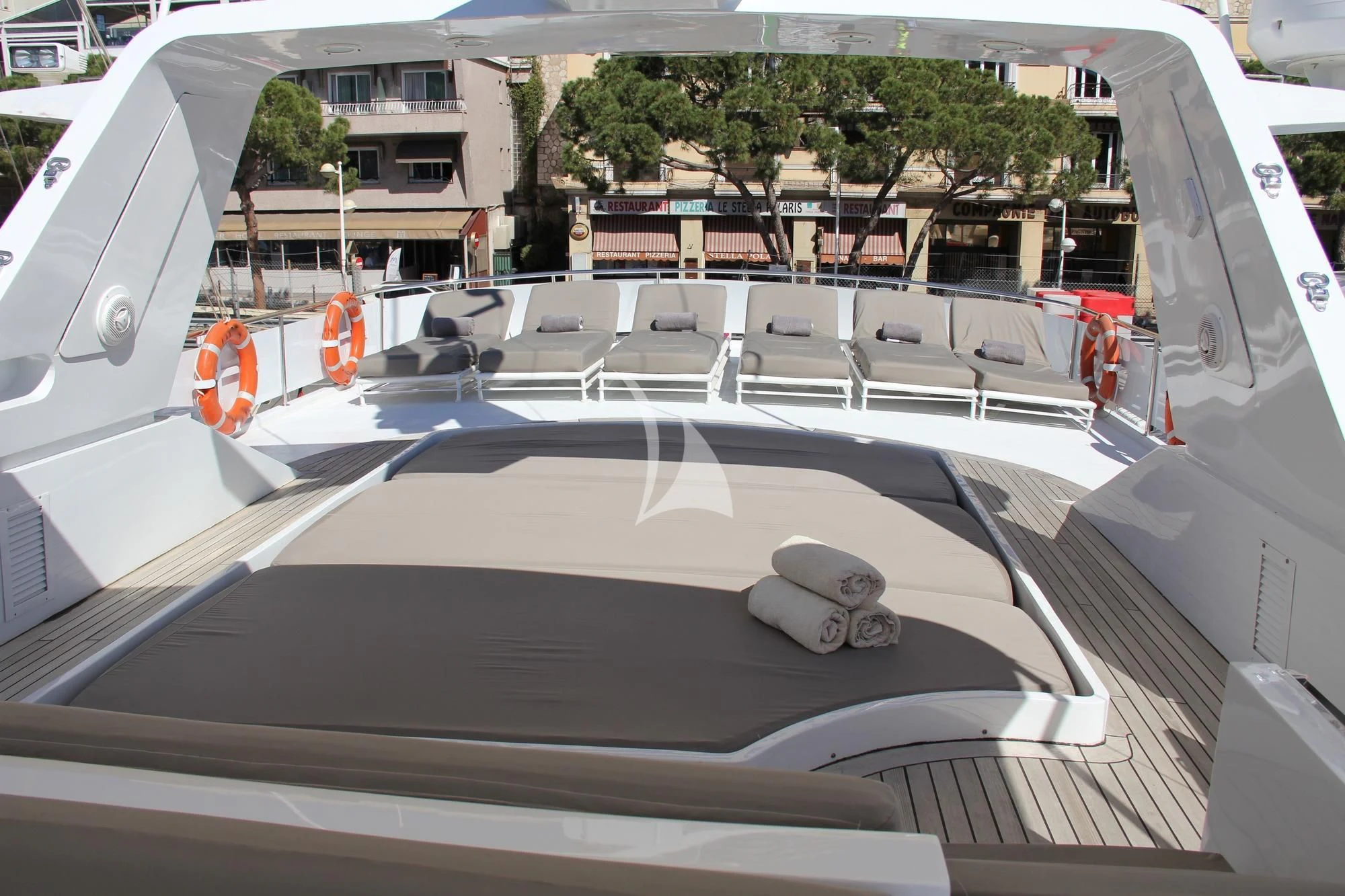 a large white car with a black hood parked on a street with buildings and trees aboard COSTA MAGNA Yacht for Sale