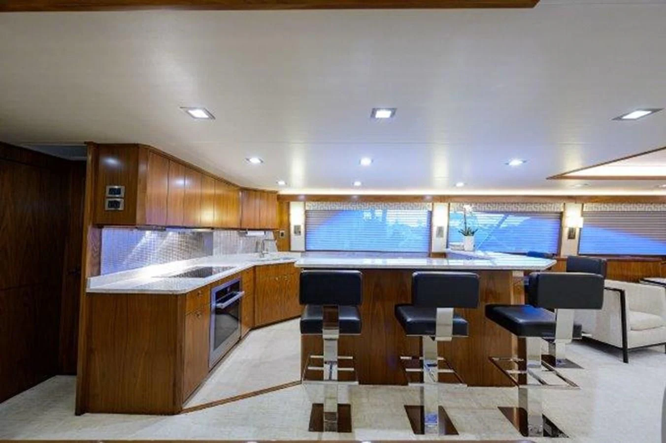 a large kitchen with a bar and chairs aboard PASTIME Yacht for Sale