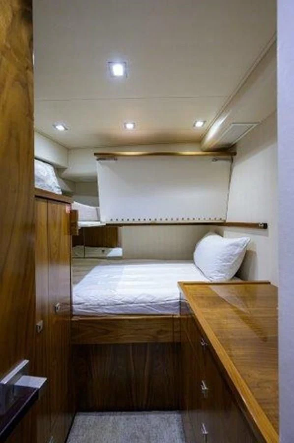 a bed with a desk aboard PASTIME Yacht for Sale