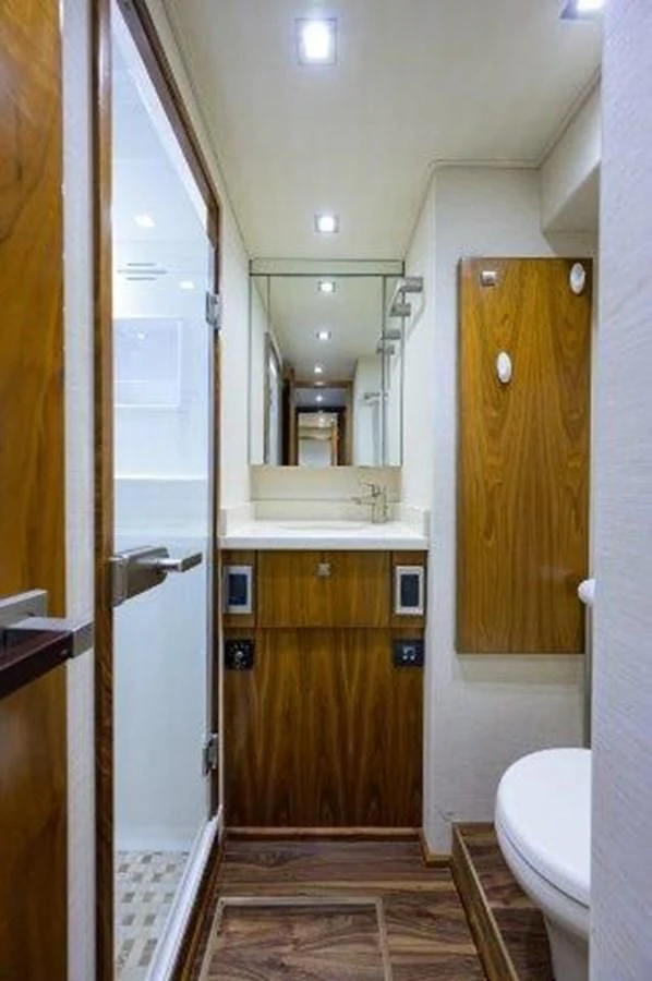 a bathroom with a wood door aboard PASTIME Yacht for Sale