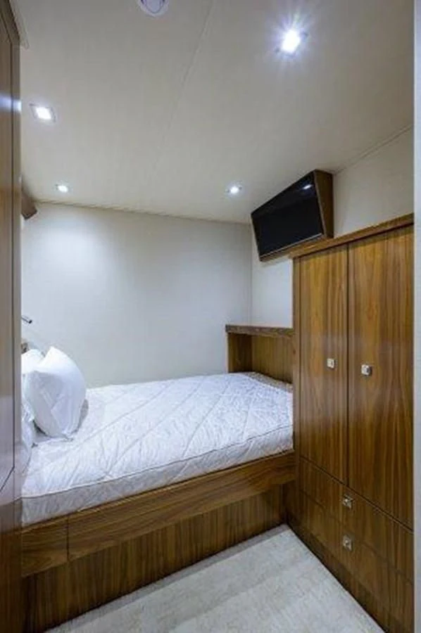a bed with a television on the wall aboard PASTIME Yacht for Sale