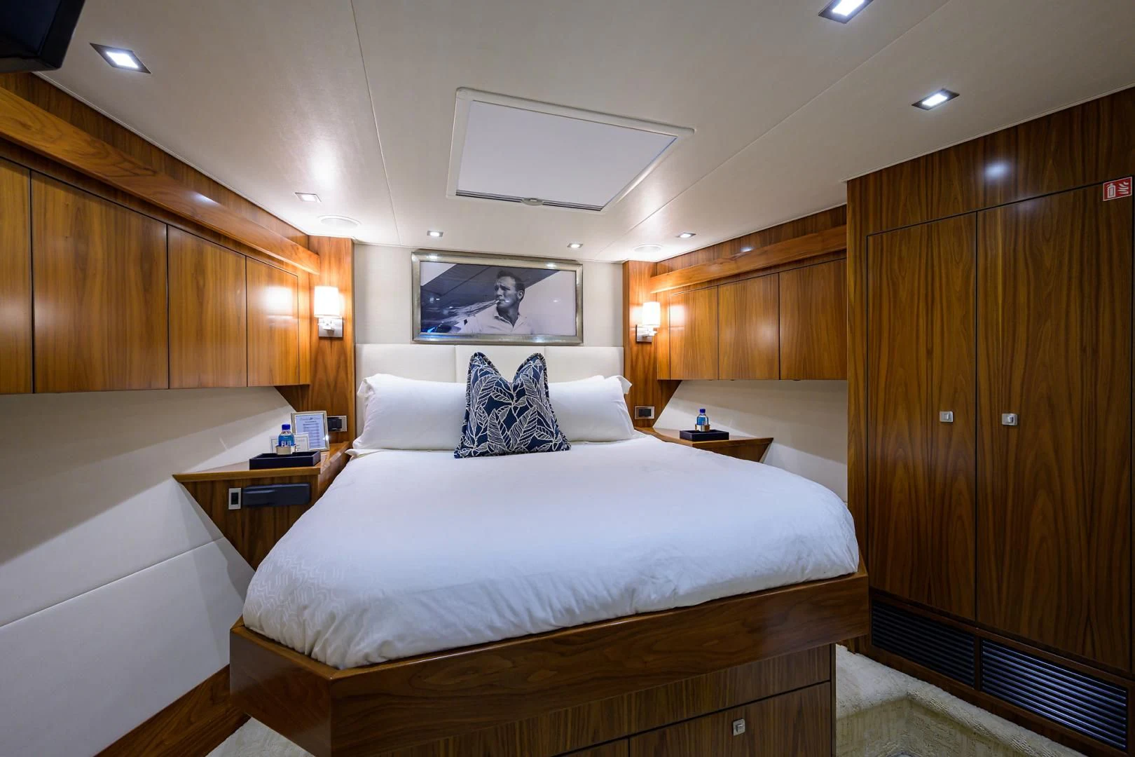 a bedroom with a bed and a wood cabinet aboard PASTIME Yacht for Sale