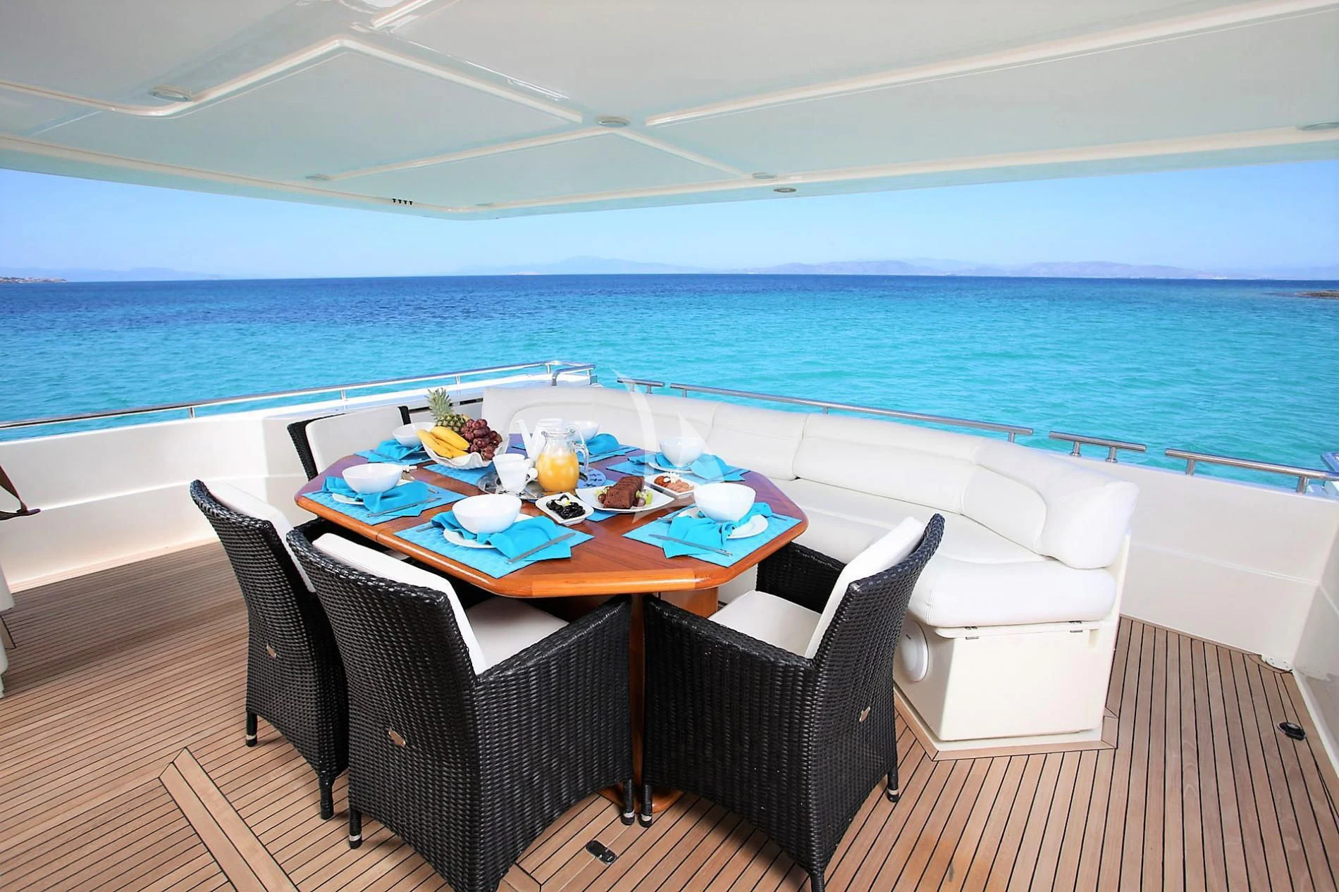 a table and chairs on a deck overlooking the ocean aboard KENTAVROS II Yacht for Charter